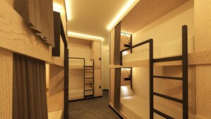 Un couloir avec des lits superposés, une échelle et un plancher en bois.