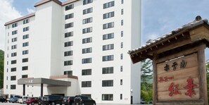 Un edificio de hotel de varios pisos con un letrero que indica 'Hotel' y 'Red Leaf'.