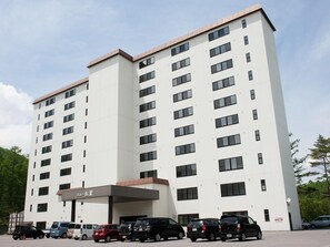 Un hôtel à plusieurs étages, doté d’une façade sobre, de nombreuses fenêtres et d’un espace d’entrée abrité.
