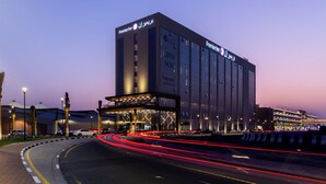 A Premier Inn hotel with a modern facade, large windows, and a prominent entrance. - Premier Inn Dragon Mart Hotel (Dubai)