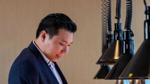 A person in a suit serving food from a buffet. - Premier Inn Dragon Mart Hotel (Dubai)