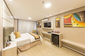 A hotel room with a bed, desk, TV, and artwork on the wall. - Hotel Global (São Paulo)