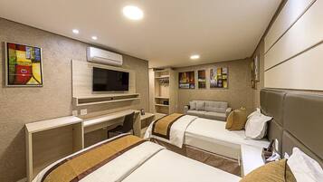 Une chambre d’hôtel avec deux lits, une télévision, un bureau et une armoire.