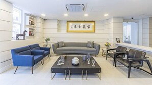 A modern living room with a sofa, chairs, a coffee table, and decorative items. - Hotel Global (São Paulo)