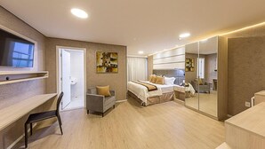 A modern hotel room with a bed, a desk, a chair, a large mirror, and artwork on the walls. - Hotel Global (São Paulo)