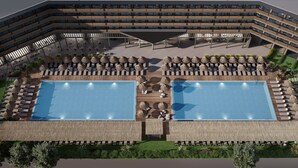 Un hotel moderno con due ampie piscine, area salotto all'aperto e un edificio a più piani con balconi.