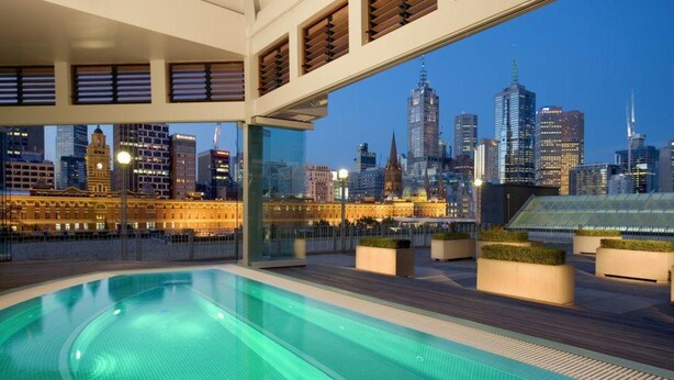 A rooftop pool with a city skyline view. - The Langham Hotel, Melbourne (Melbourne)
