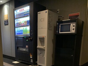 Automaatti, jossa on Kirin-juomavalikoima, jääpala-annostelija ja mikroaaltouuni.