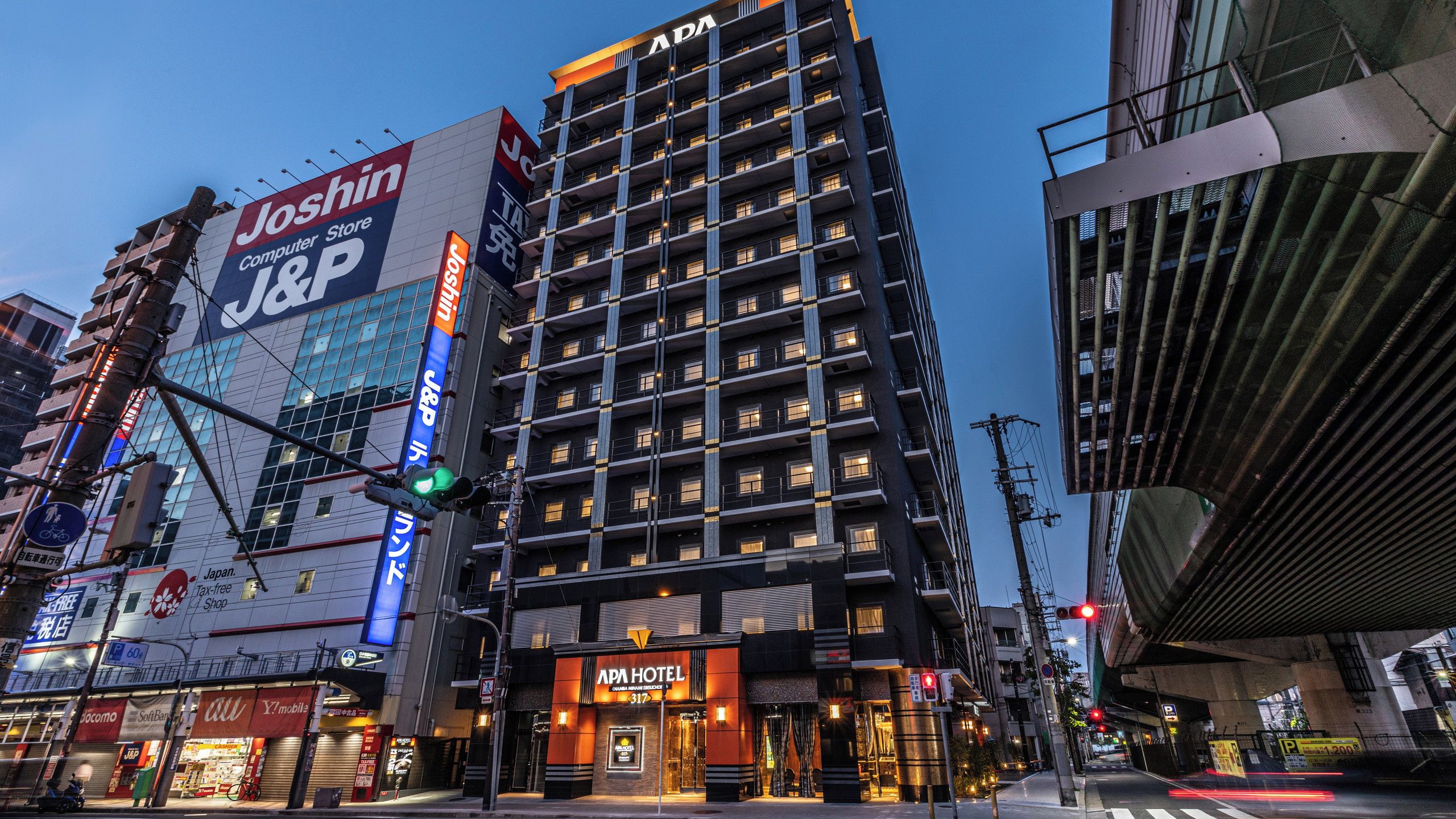 A multi-story building with a prominent JOSHIN Computer Store sign on the side.