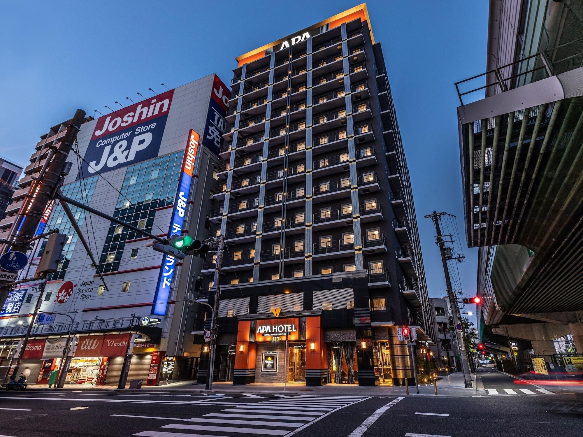A multi-story building with a prominent J&P sign, an APA Hotel, and various commercial establishments.