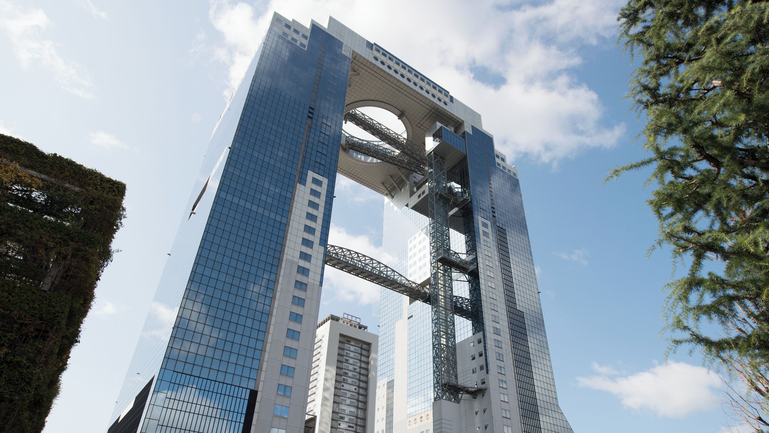 A modern skyscraper with a distinctive arch structure, surrounded by other high-rise buildings.
