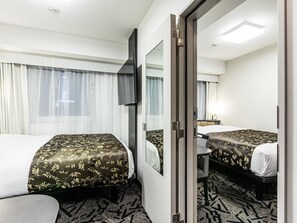 Hotellihuone, jossa on kaksi sänkyä, suuri peili, taulutelevisio ja ikkuna, jossa on verhot.
