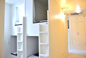 A room with bunk beds, a wardrobe, and a radiator. - Almond Hostel And Cafe (Tokyo)
