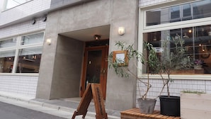 Un edificio con fachada de hormigón, ventanas amplias y puerta de madera.