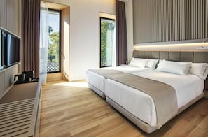 A modern hotel room with a large bed, a flat-screen TV, and a balcony with curtains. - Hotel Kivir Sevilla (Seville)