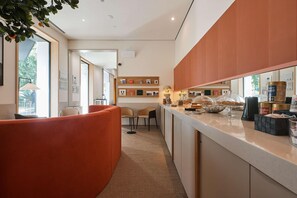 A modern hotel lobby with a curved orange seating area, a reception desk, and a view of the outdoors. - Hotel Kivir Sevilla (Seville)