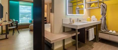 A modern bathroom with a large mirror, a vanity, and a towel rack.