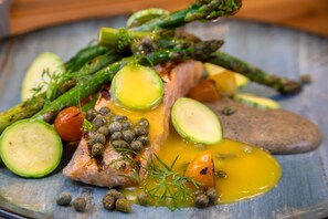 Ein Teller mit Spargel, Tomaten und einem Fischfilet.