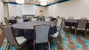 A conference room with round tables, chairs, a projector screen, and a carpeted floor. - Drury Inn Suites Phoenix Chandler Fashion Center (Phoenix)