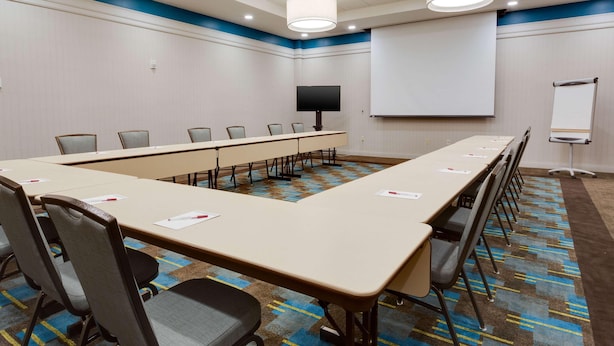A conference room with a long table, chairs, a projector screen, and a whiteboard. - Drury Inn Suites Phoenix Chandler Fashion Center (Phoenix)