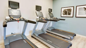 Three treadmills with digital displays, a wall-mounted TV, and framed artwork. - Drury Inn Suites Phoenix Chandler Fashion Center (Phoenix)