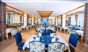 A restaurant with a long table set for dining, surrounded by chairs with patterned upholstery. - New Eagles Resort & Aqua Park (Hurghada)