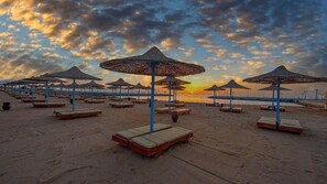 A beach with sun loungers and thatched umbrellas. - New Eagles Resort & Aqua Park (Hurghada)