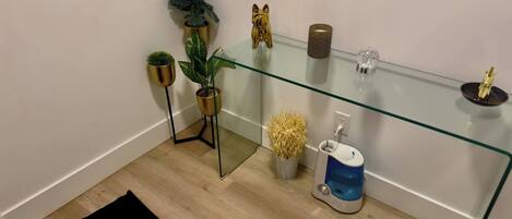 A modern bathroom with a glass shower enclosure, a toilet, and a small potted plant.