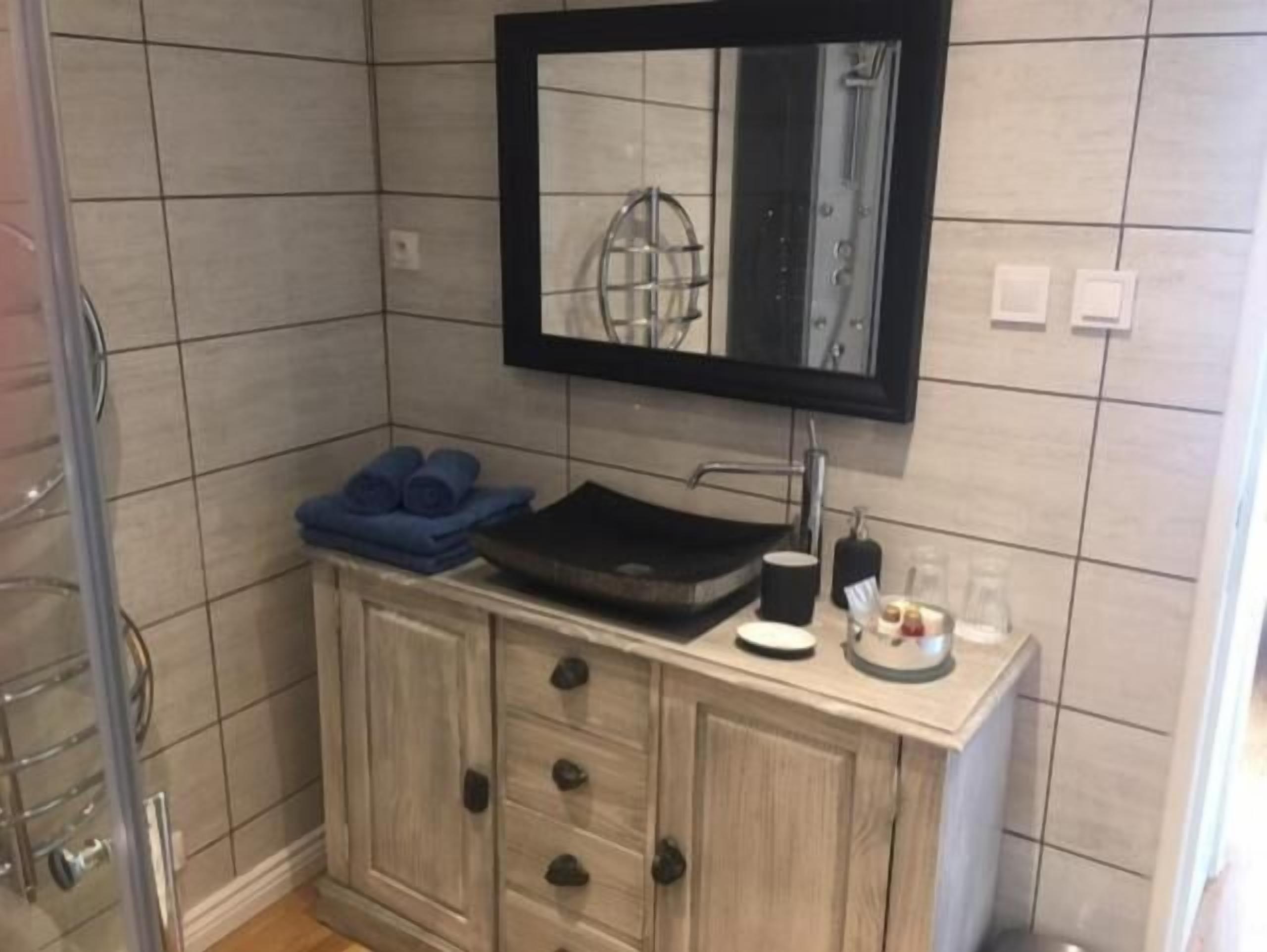 A bathroom with a sink, mirror, and towel rack.