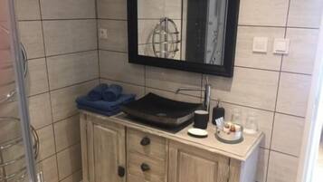 A bathroom with a sink, mirror, and towel rack.