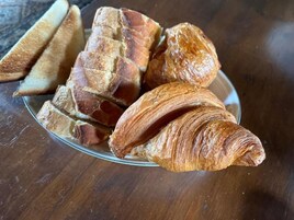 Un plato con pan y un croissant.