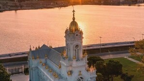 Un edificio grande y ornamentado con una cúpula destacada y múltiples torres, ubicado junto a la costa.