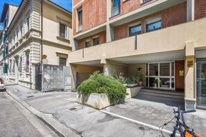 A building with a modern facade, a gated entrance, and a bicycle parked in front. - Sara Studio Apartment (Florence)