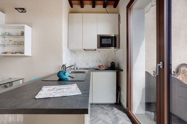 A compact kitchen with a microwave, a small refrigerator, and a sink. - Apartment 'Incantevole - Fosdinovo' with Mountain View, Wi-Fi and Air Conditioning (Fosdinovo)