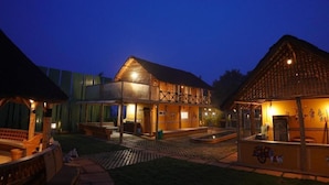 A traditional wooden building with a balcony, a covered seating area, and a small outdoor kitchen.