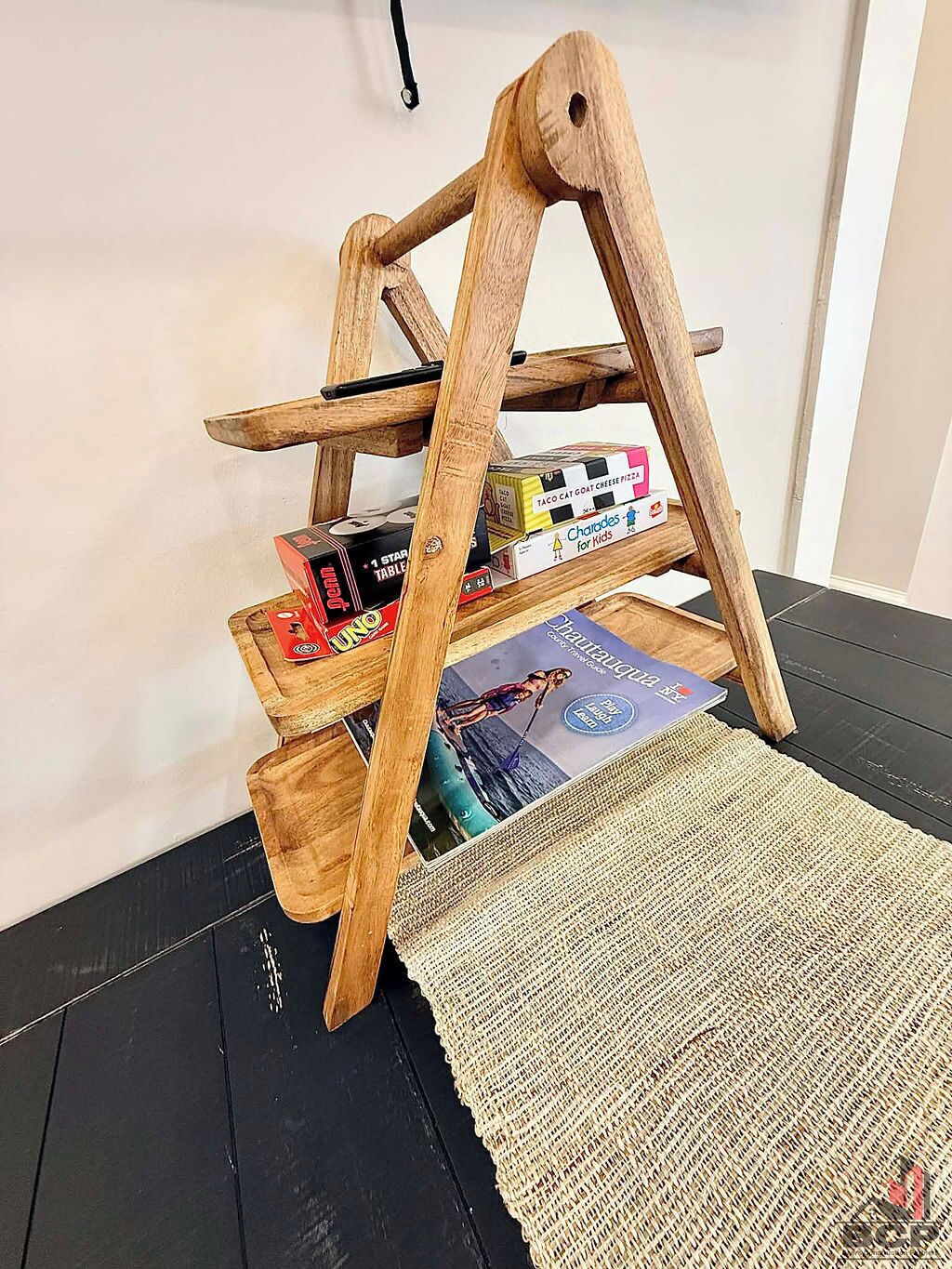 A wooden bookshelf with books and board games.