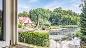 Ein Fluss mit einem Haus im Hintergrund.