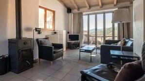A living room with a fireplace, a sofa, a TV, and a view of the outdoors. - Cadro Casa Vista (4guests) (SESTRI LEVANTE)