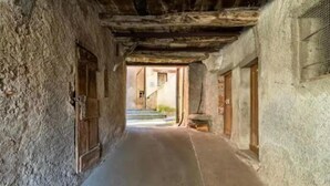 A narrow corridor with rough stone walls, wooden doors, and a staircase leading to an upper level. - Cadro Casa Vista (4guests) (SESTRI LEVANTE)