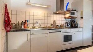 A kitchen with white cabinets, a microwave, a stove, and a sink. - Cadro Casa Vista (4guests) (SESTRI LEVANTE)