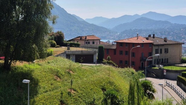 A residential area with houses, a street, and mountains in the background. - PREGASSONA Executive Apartment Lake View and Garden (8persons) (Lugano Pregassona)