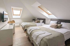 Een slaapkamer met twee bedden, een bureau en een raam.