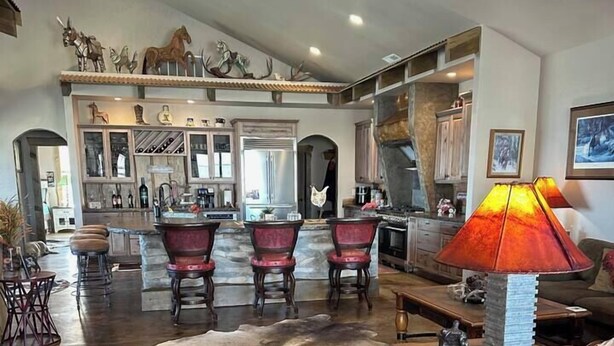 A spacious living area with a large cowhide rug, a dining table with chairs, a coffee table, and a lamp. - Lake Roosevelt Retreat - Spring Canyon Boat Launch (Grand Coulee)