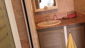 A bathroom with a sink, mirror, towel rack, and a shower area. - Air-conditioned apartment for 4 near town center. Small dogs accepted (La Londe-les-Maures)