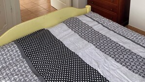 A bedroom with a bed, a dresser, a desk, and a chair in the background. - Air-conditioned apartment for 4 near town center. Small dogs accepted (La Londe-les-Maures)