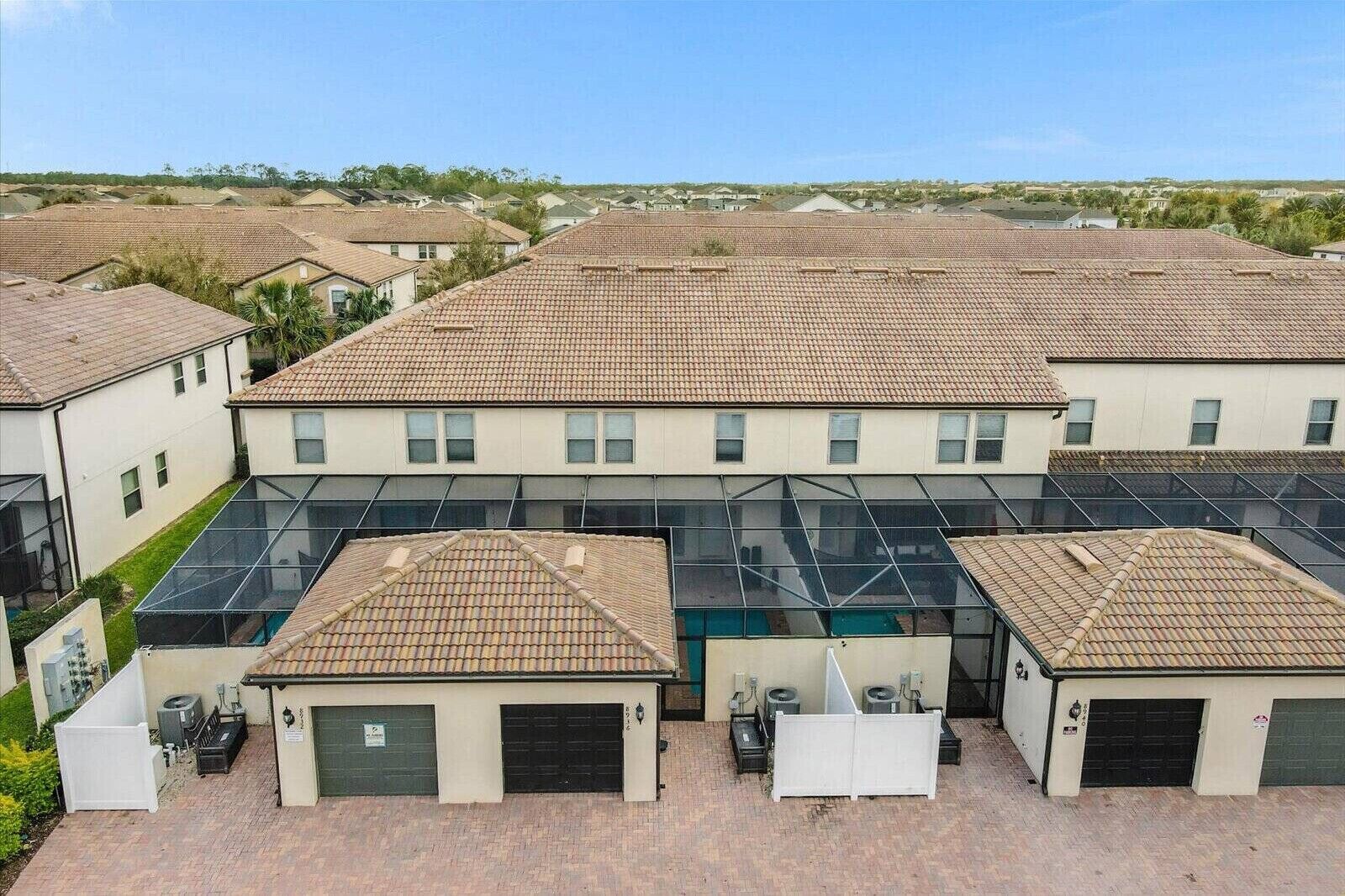 Una zona residenziale con diverse case, ciascuna dotata di tetto in tegole e di un garage.