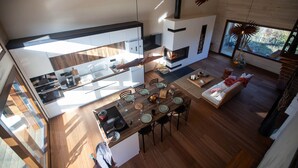 Une cuisine moderne avec un coin repas, une cheminée et une vue sur l’extérieur.