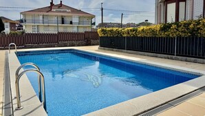 A rectangular swimming pool with a metal ladder on the left, surrounded by a concrete deck. - Apartment Playa Azul - 5924 (Isla)