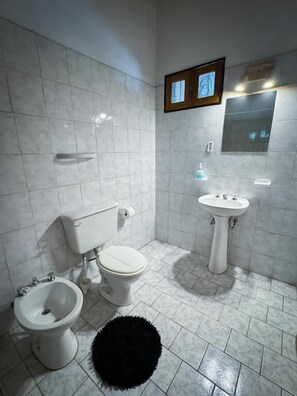 A bathroom with a toilet, bidet, sink, and mirror. - Hotel Alta Mendoza (Mendoza)