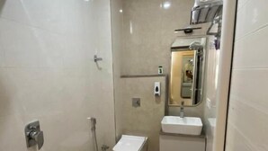 A bathroom with a shower, toilet, sink, and mirror. - R J Residency  (Varanasi)